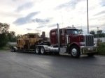 A piece of work equipment from Delta Railroad Construction sits on a flatbed in the Super 8 Motel parking lot